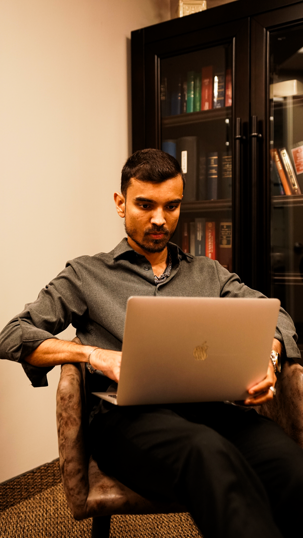 a man sitting in a chair looking at a computer screen